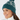 Teal women’s knit golf beanie with white pattern, ribbed cuff and pom-pom, shown on a model.