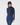 A woman wearing a navy blue long-sleeve mock neck golf top and matching navy blue pants, paired with a navy beanie hat.