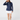 Navy women’s long sleeve quarter-zip golf pullover paired with a white golf skort and navy socks.