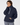A woman wearing a navy blue quilted lightweight jacket with a white zipper and patterned leggings, posing against a light gray studio background.