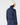 A woman shown from the back wearing a navy blue textured knit mock-neck golf top with white embroidered star patterns, paired with a cream ribbed beanie and navy leggings.