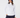A woman wearing a white quarter-zip golf pullover paired with navy pants and a navy fuzzy bucket hat.