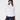 A woman wearing a white quarter-zip golf pullover paired with navy pants and a navy fuzzy bucket hat.