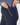 Close-up of a person shown from the side wearing dark navy pants with a patterned navy-and-white top.