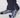 A close-up of a person's feet wearing navy blue socks with a white geometric pattern, paired with dark navy trousers.