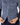 A close-up of a person wearing a navy blue long-sleeve button-up shirt with a white geometric pattern, paired with navy golf pants.