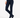 A model wearing navy blue slip-on boots, a pair of dark navy blue slim-fit trousers, and styled with a white long-sleeve top.