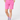 A model is shown from the waist down wearing bright pink golf shorts, a white belt, patterned ladies golf socks, and a patterned top.