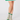A person's legs wearing green and white patterned ladies golf socks with a matching green and white skirt.