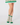 A person's legs wearing green and white patterned ladies golf socks with a matching green and white skirt.