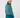 Teal women’s pattern golf sweater with turtleneck and ribbed cuffs, modeled from the back.
