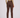 A model shown from the back wearing slim-fit brown golf trousers, a patterned long-sleeve top, and white trainers.