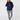 A woman wearing a navy blue half-zip pullover hoodie and matching navy and white patterned leggings.