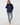 A woman wearing a navy blue half-zip pullover hoodie and matching navy and white patterned leggings.
