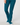 A person wearing teal-blue pants and matching golf socks with white toes, shown from the waist down.