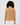 Women wearing caramel ribbed golf sweater paired with white pants, back view.
