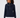 A woman wearing a navy blue ribbed knit sweater with a mock neck and gold zipper detail, paired with white pants.
