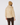 A person shown from the back wearing a light beige puffer jacket, a tan knit beanie, and dark brown pants.