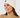 White women’s cable-knit golf beanie with ribbed cuff and circular star logo, shown on a model.
