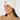 White women’s cable-knit golf beanie with ribbed cuff and circular star logo, shown on a model.