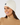 White women’s cable-knit golf beanie with ribbed cuff and circular star logo, shown on a model.