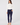 Woman wearing the Natasha white mock neck long-sleeve top with a pair of navy blue skinny pants.