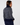 A woman shown from the back wearing the Donna navy blue knit golf sweater with a white geometric pattern and a solid navy mock neck, ribbed hem, and cuffs, paired with navy trousers.