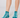 A pair of teal low-cut golf socks with a white abstract wavy pattern, shown on a model's feet.