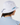 A person shown from the back wearing a white bucket hat with a light blue drawstring and a light blue collared shirt.