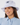 A smiling woman wearing a light lavender bucket hat with a dark embroidered star on the front, paired with a light blue collared blouse.