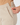 Close-up of parchment women’s heavyweight golf trousers showing the side zipper and angled pocket.