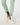 Beige women’s winter golf boots with black side panels and white soles, styled with patterned golf leggings.