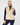 Front view of a woman wearing a ribbed knit quarter-zip golf vest in cream, worn over a navy long-sleeve top and paired with navy leggings and a cream beanie with a navy stripe.