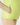Close-up of a person wearing a bright lime green puffer jacket with a zippered front and side pocket, paired with beige pants. A patterned cream, brown, and blue sleeve is tucked into the pocket.