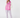 A woman modeling a pink puffer vest, pink knit beanie, white long-sleeve top, white and pink patterned leggings, and blue rain boots.