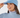 A woman wearing a light blue ribbed knit beanie with a small embroidered logo on the front, paired with a patterned neck gaiter and a matching light blue turtleneck top.