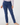 A person wearing a pair of slim-fit navy blue pants, shown from the waist down against a plain light gray studio background. The pants have a small star logo on the fob pocket.