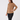 A woman modeling a tan long-sleeve quarter-zip fleece pullover against a plain light gray studio background.