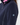 Close-up of a person wearing a dark navy fleece zip-up jacket with a small circular star logo patch on the upper left sleeve, over a pink inner layer.