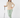 Beige women’s quarter-zip golf pullover paired with green patterned golf leggings and matching headband.