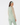 Beige women’s quarter-zip golf pullover with green patterned back panel, shown from the back.