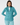 Teal women’s quarter-zip golf pullover with patterned trim, paired with matching patterned golf leggings.