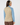 Blue women’s quarter-zip golf pullover with colorful geometric back panel and solid sleeves, shown from the back.