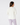 A woman shown from the back wearing a cream-colored long-sleeve top and light purple patterned pajama pants.