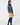 Navy women’s padded golf jacket paired with a caramel winter golf skirt, shown from the back.