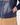 Close-up of a navy women’s padded golf jacket showing the side pocket, silver zipper and star charm.