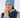 Blue women’s cable-knit golf beanie with ribbed cuff and star logo patch, shown on a smiling model.