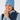 Blue women’s cable-knit golf beanie with ribbed cuff and star logo patch, shown on a smiling model.