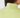 Close-up back view of a person wearing a ribbed high-neck top in light yellow-green, with a small embroidered star logo centered below the collar.
