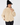 Parchment women’s fleece golf jacket with full zip and contrast panels, styled with a black bobble hat, front view.